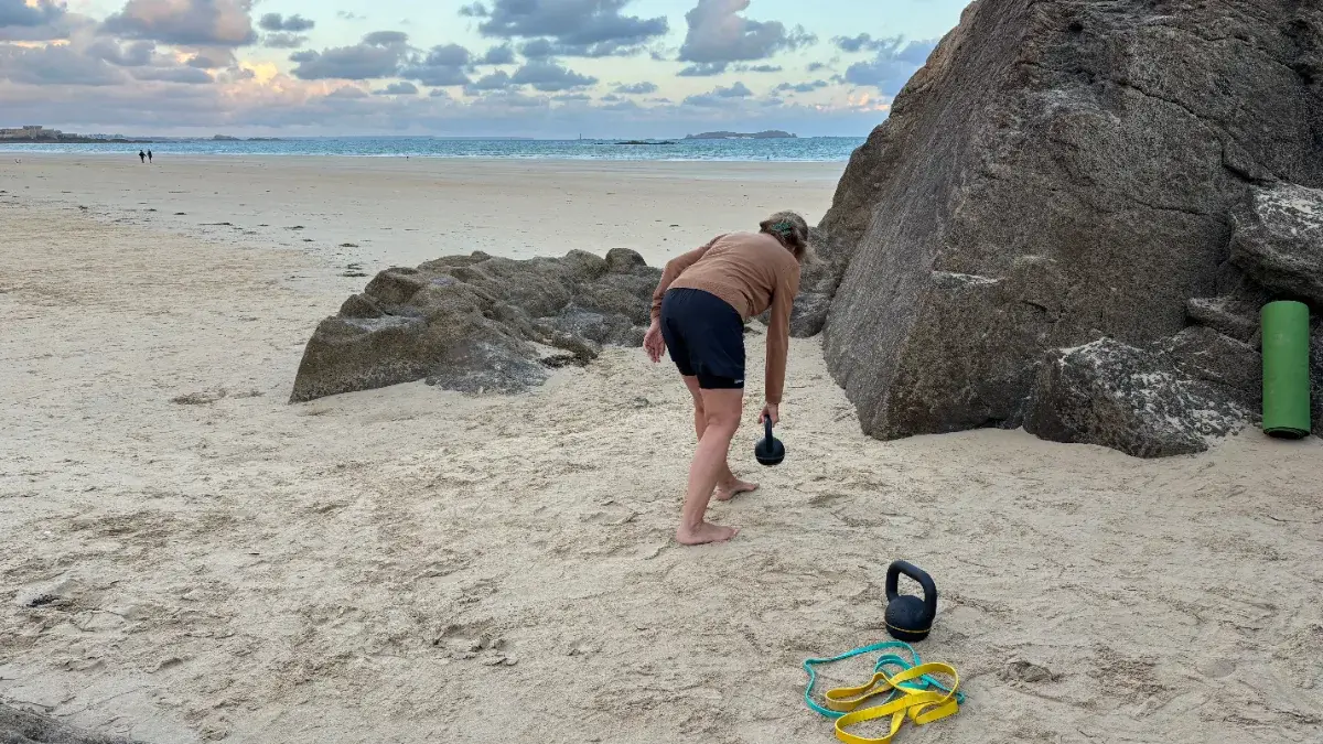 Séance de coaching individuel sur la plage de Saint-Malo, soulevé de terre à la kettlebell