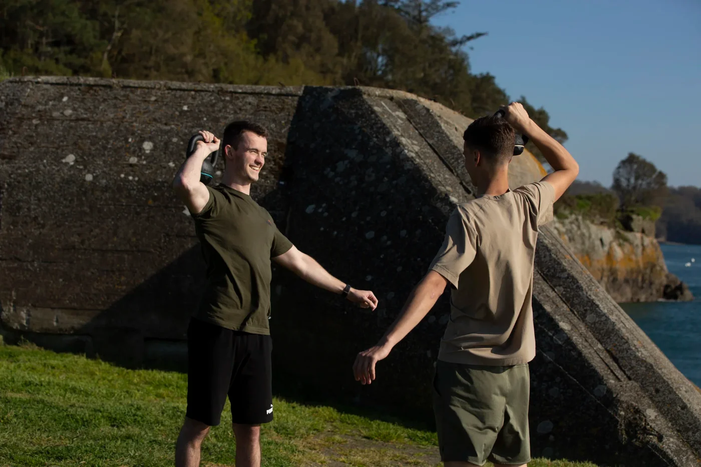 Erwan Brévault montrant un mouvement kettlebell à un client en extérieur